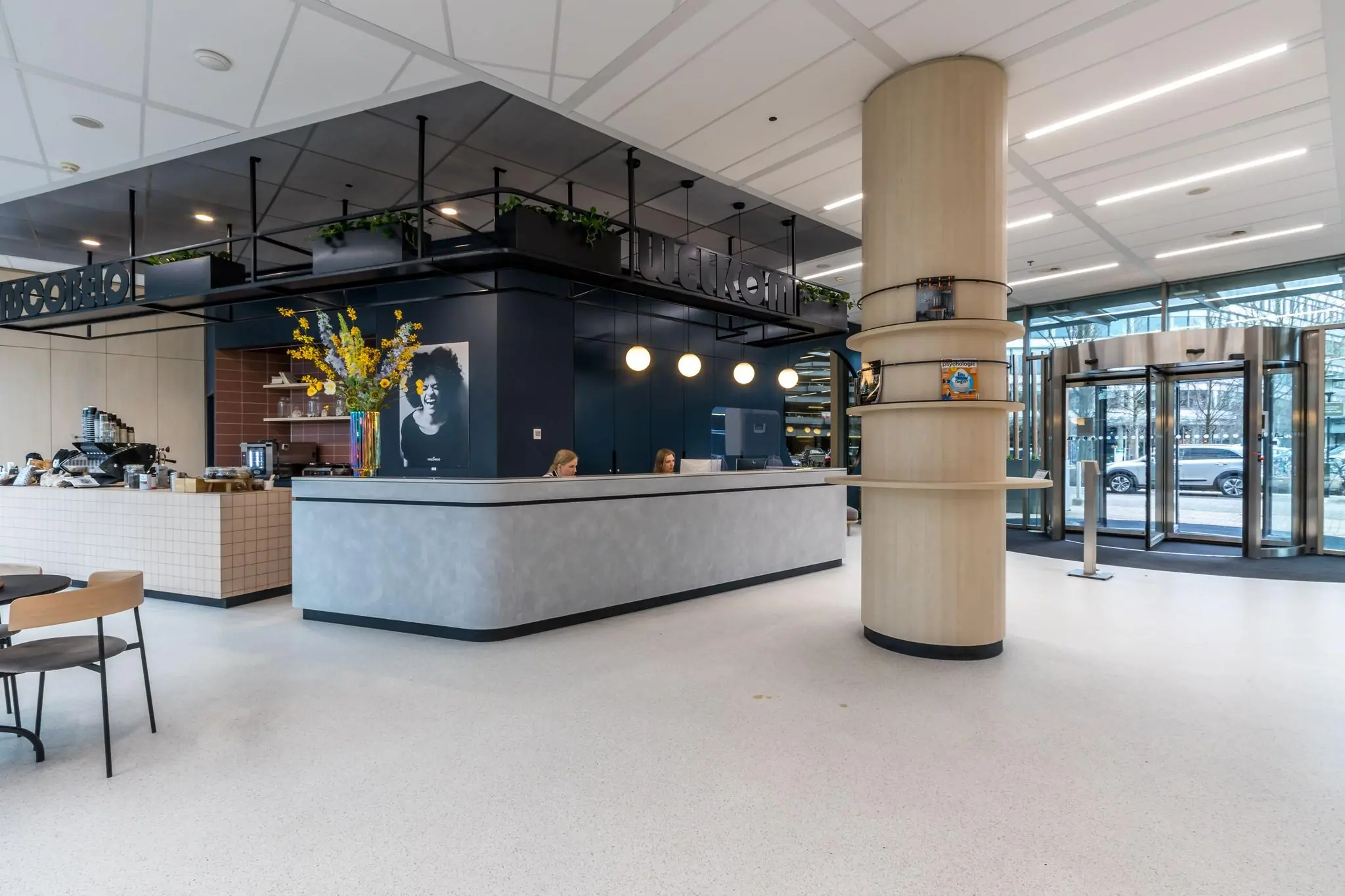 Moderne en lichte entree met een receptiebalie, zitgedeelte en koffiezaak aan de Vliegend Hertlaan.